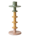 A three-tiered enameled metal taper candle holder in green, tan, and pink colors with a round base and a top hole for inserting a taper candle.