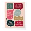 A set of folded Christmas greeting cards with various holiday greetings in different languages, featuring a Christmas tree and holiday decorations, printed on white card stock.