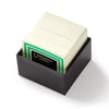 Stack of white sugar packets in a black holder with 'A Spoonful of Sugar' branding on a white background.