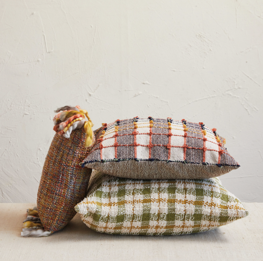 Decorative tortoise-shaped pillow with plaid patterns on a neutral background