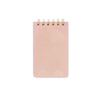 Pink notebook with gold arch design on a white background