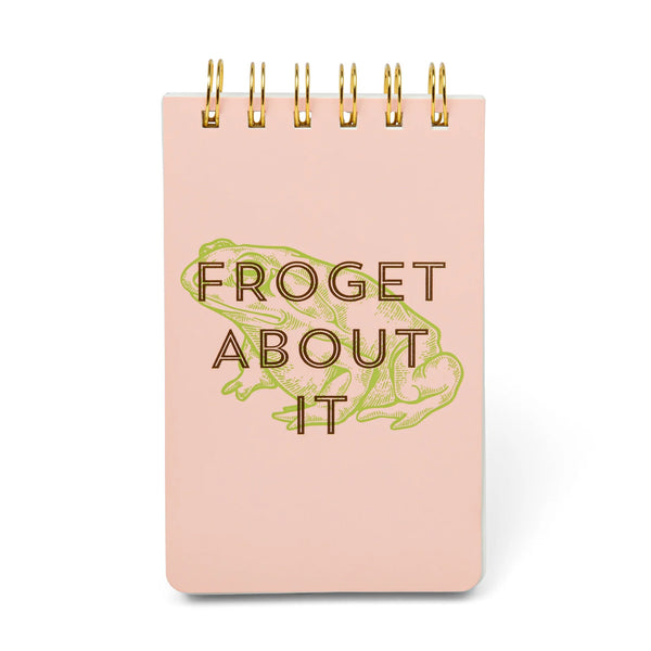 Pink notebook with gold text 'Froget About It' on a white background