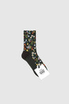 A pair of women's crew socks with a floral pattern in various colors on a dark green background, displayed with a tag.