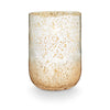 A large radiant glass candle with a two-tone metallic finish, predominantly in shades of beige and white.