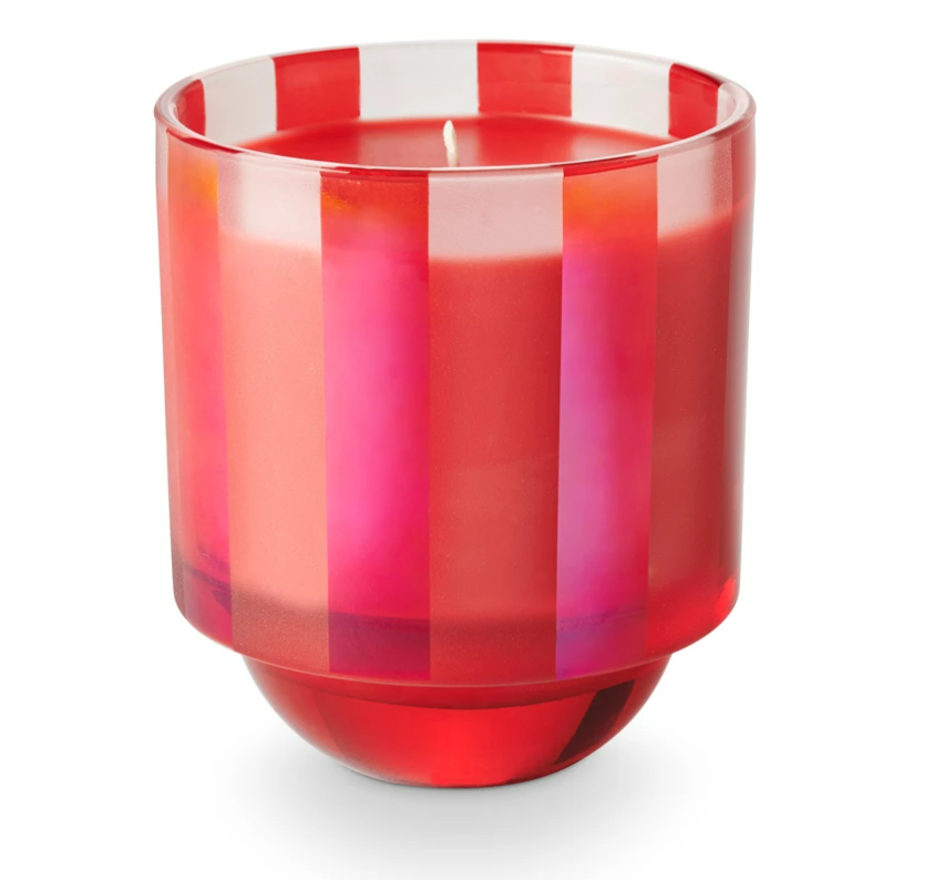 A boxed glass candle with red and pink stripes designed for holiday use.