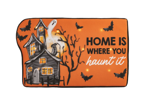 Halloween-themed decorative mat with haunted house and text on an orange background