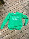 Green sweatshirt with text on a wooden surface