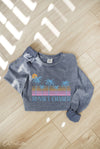 Gray sweatshirt with 'Sunset Chaser' design on a wooden floor