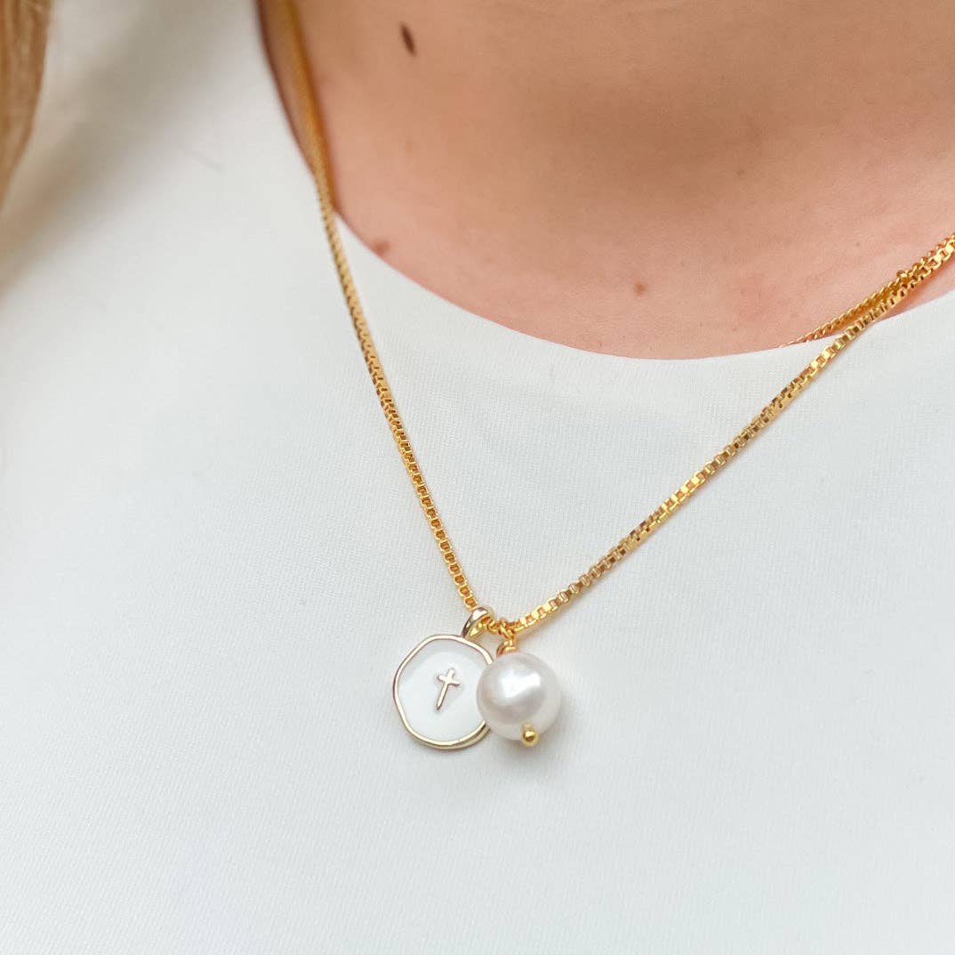 Gold necklace with a pearl pendant on a white background