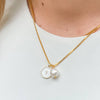 Gold necklace with a pearl pendant on a white background