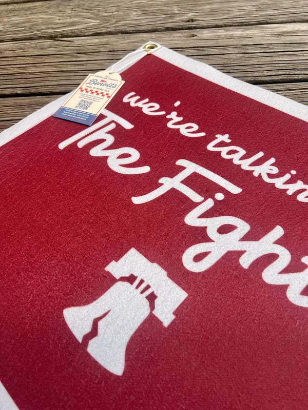 Red towel with white text and graphic on a wooden surface