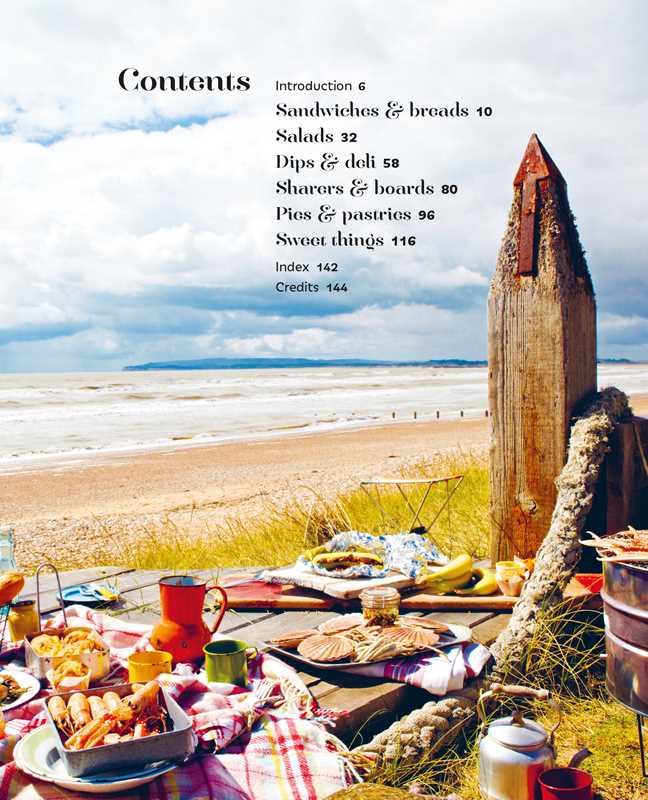 Table with food on a beach with a wooden sculpture in the background