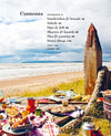 Table with food on a beach with a wooden sculpture in the background