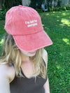 Person wearing a pink cap with 'I'm not for everyone' text outdoors.