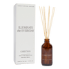 A Christmas amber reed diffuser by Sweet Water Decor with a clear glass bottle, brown reeds, and a white box packaging.