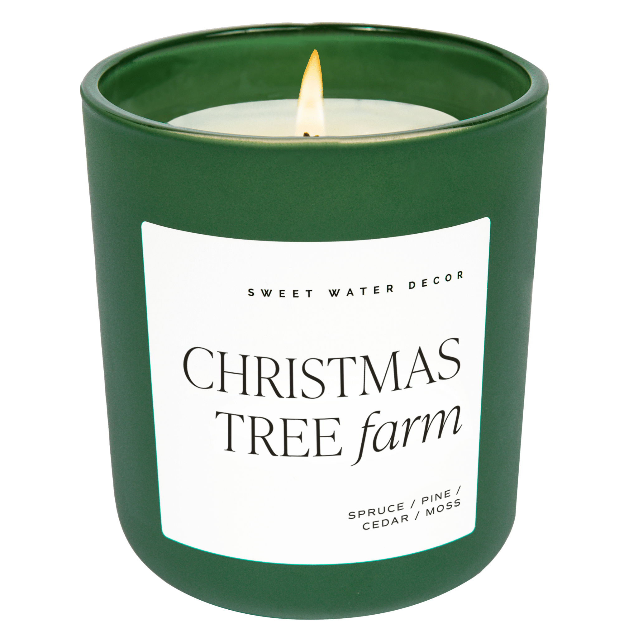 A green matte glass jar with a label that reads 'Christmas Tree Farm' and a brief description of the scents including pine, spruce, and cedarwood.