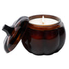 Candle in a brown glass jar with a lid on a white background