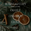 Text 'Warm and Cozy Smells Like Orange, Cinnamon, Clove, Pine' with dried oranges, cinnamon stick, and pine branches on a dark background.