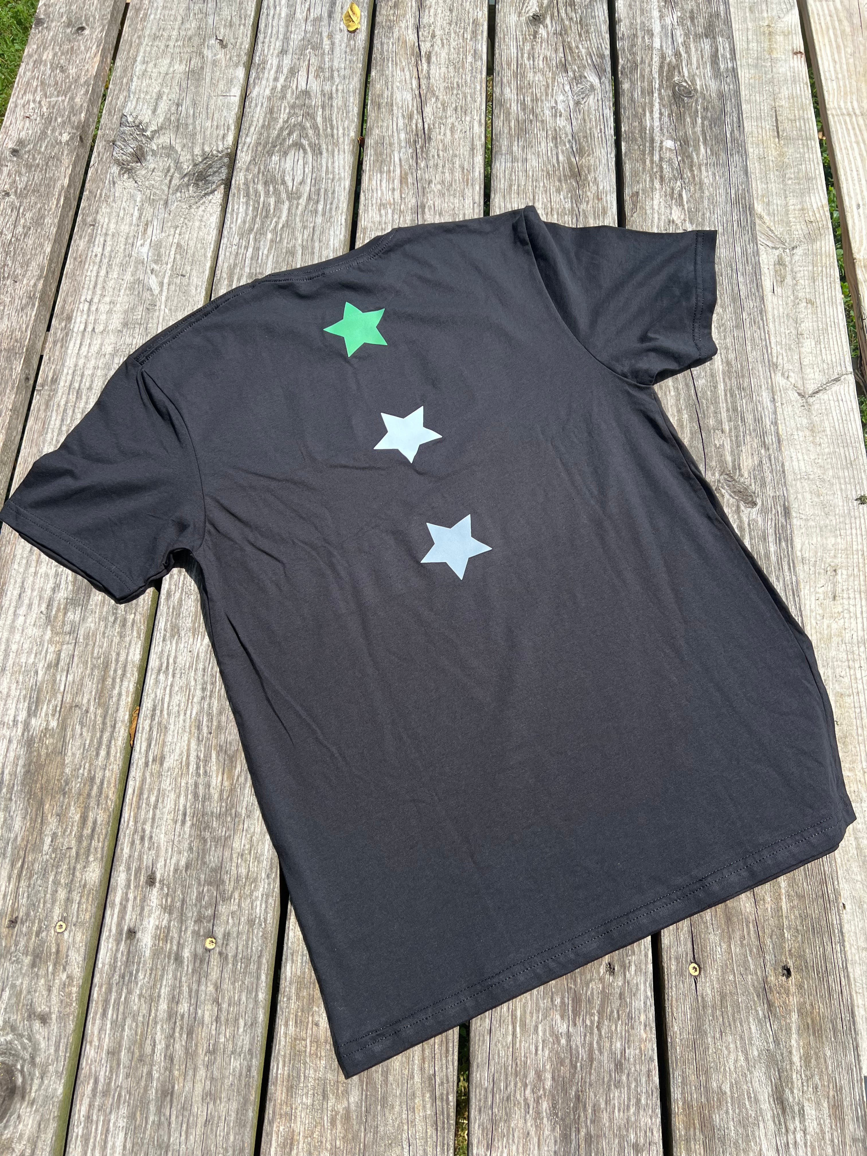 Black t-shirt with star designs on a wooden surface