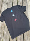 Black t-shirt with colorful stars on a wooden surface