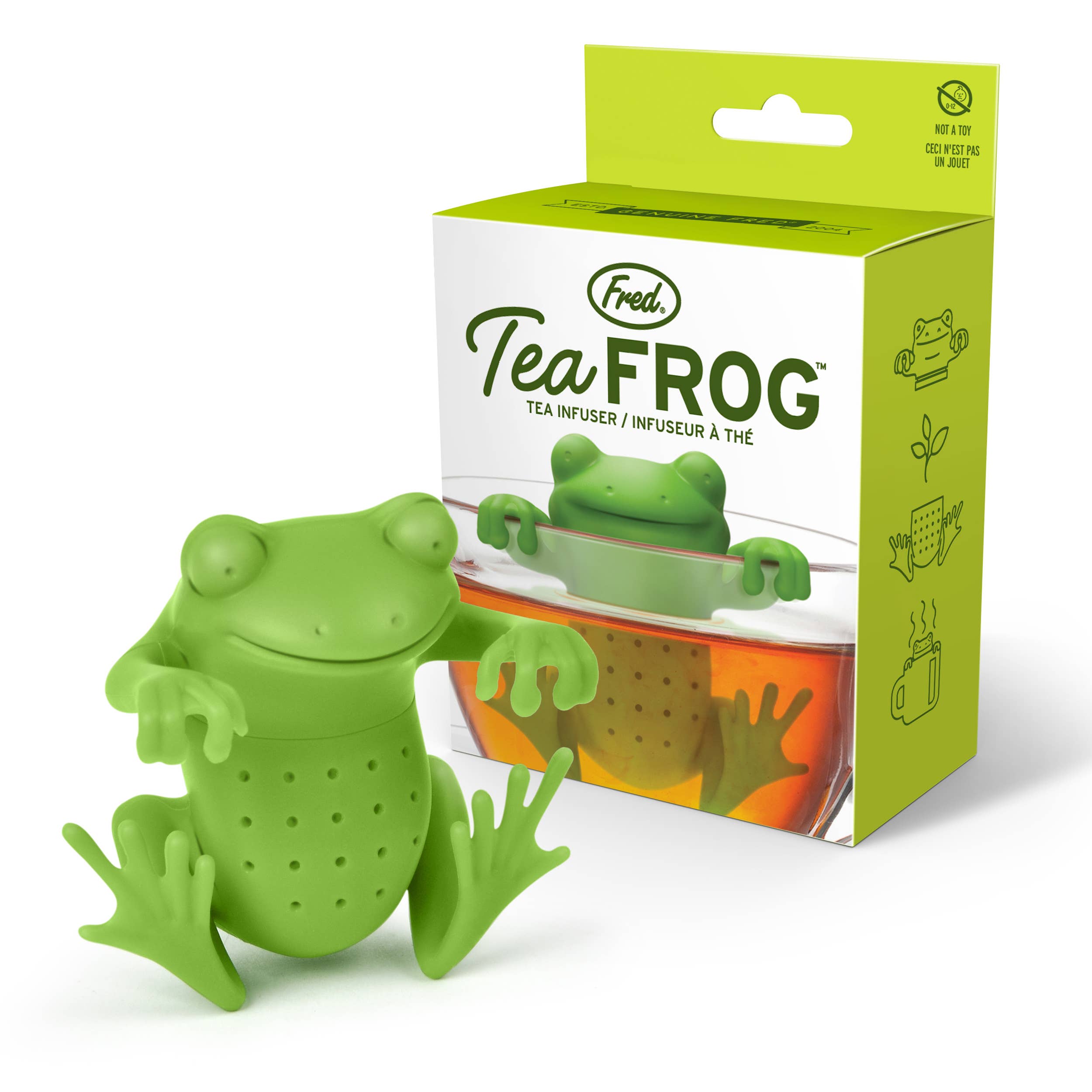 A green silicone tea infuser designed to look like a frog, displayed alongside its packaging.