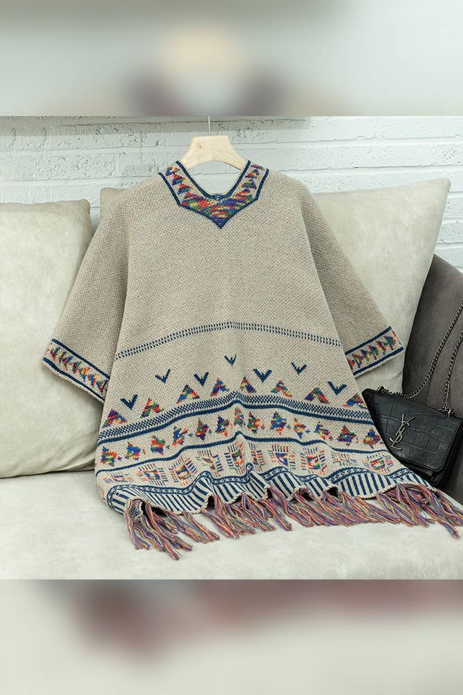 Beige embroidered dress with colorful patterns on a hanger against a neutral background