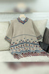 Beige embroidered dress with colorful patterns on a hanger against a neutral background