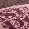 Decorative letter 'S' with floral elements on a wooden surface