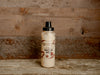A bottle of bacon garnishing aioli squeeze with a wooden background.