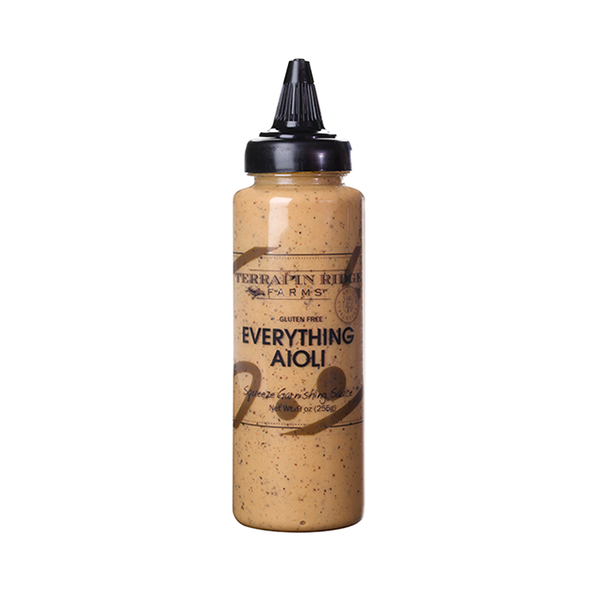 A squeeze bottle labeled 'Terrapin Ridge Everything Garnishing Aioli' with a brownish sauce visible inside the bottle.