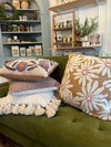 Green sofa with decorative pillows and a shelf in the background