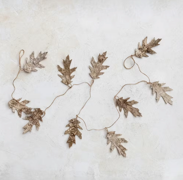 Decorative leaf garland on a textured white surface