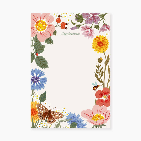 A notepad with a floral pattern including flowers in various colors and a butterfly, with the word 'Daydreams' written at the top.