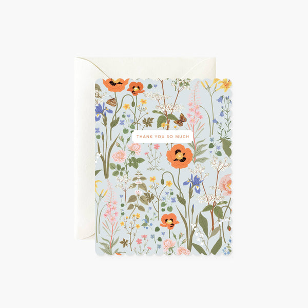 A folded thank you card with a floral design, heavy card stock, and scalloped die-cut edges.