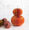 Decorative paper pumpkins on a white surface with a light background
