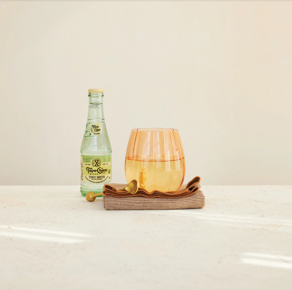 Bottle of Tupperware on a white surface with a neutral background