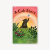 Book cover of 'A Cub Story' with a bear, butterfly, and sunset design.