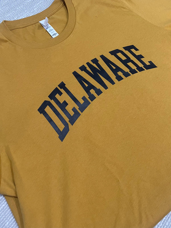 Yellow t-shirt with 'DELAWARE' printed in black on a textured surface