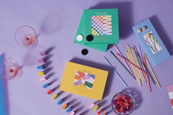 Colorful stationery items including notebooks and markers on a purple surface.