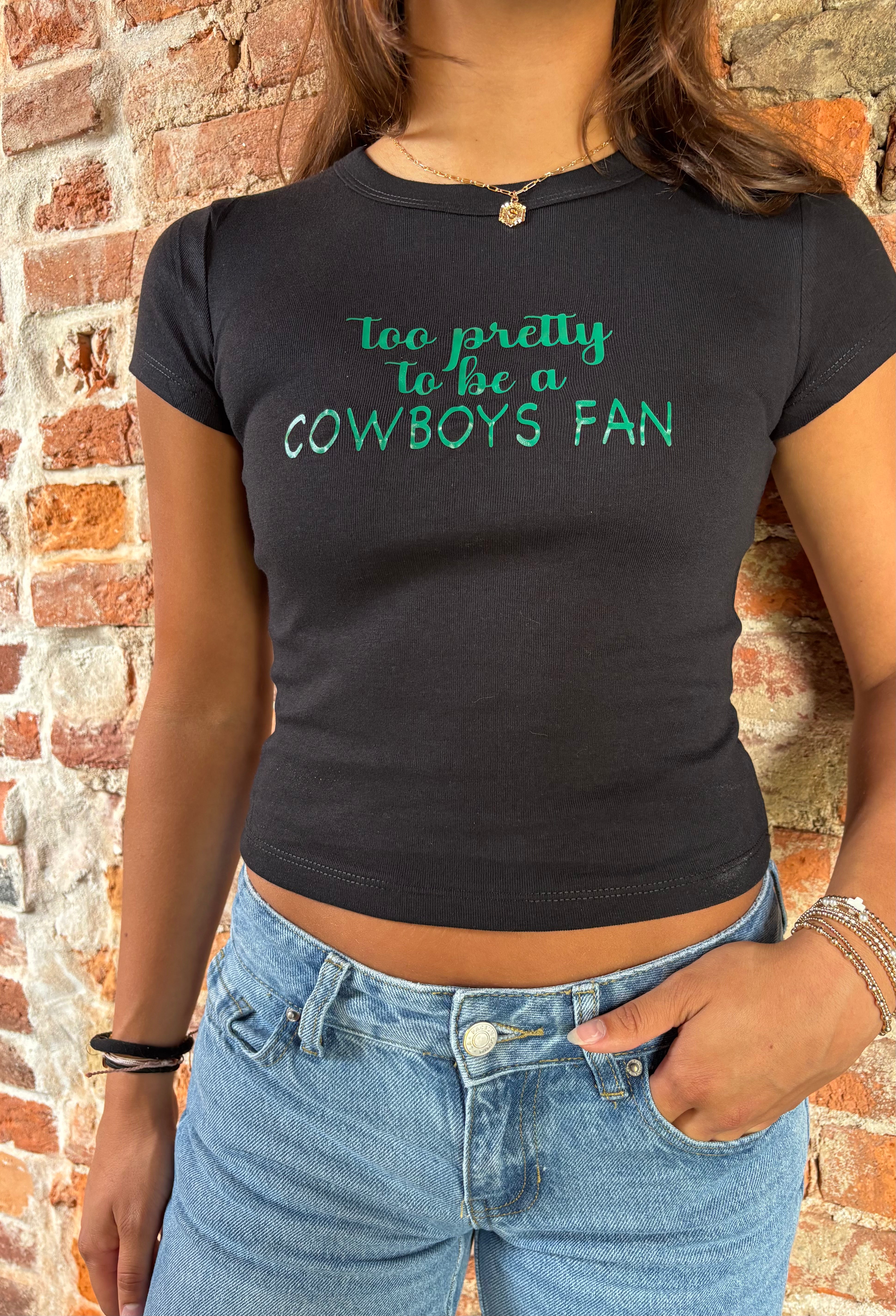 Person wearing a black t-shirt with green text against a brick wall