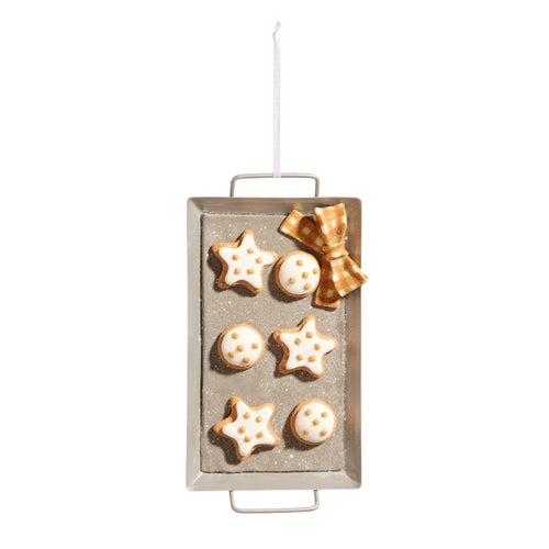 A gingerbread cookie sheet ornament with star and circle design, hanging from a metal wire. It features white sprinkle cookies and a yellow gingham bow.