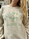Beige sweatshirt with 'Griswold Eggnog Co.' text and logo worn by a person.