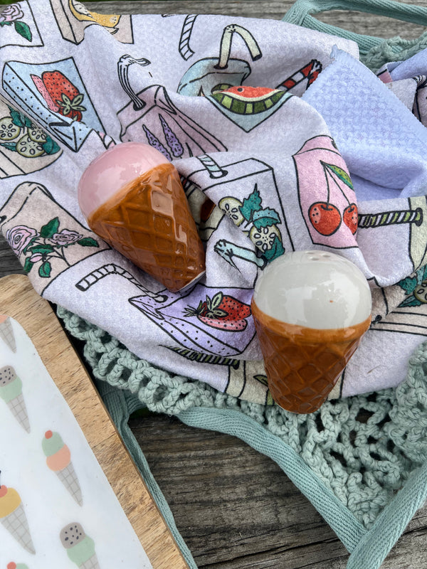 Decorative towel with ice cream-themed illustrations featuring a pink ice cream, brown cone, and white scoop.