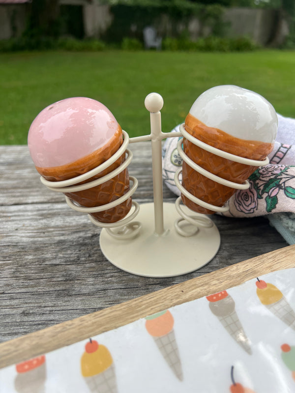 Decorative stand with spherical ceramic items on a wooden surface outdoors.