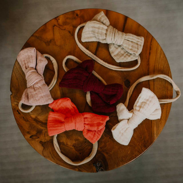 Set of colorful bow-shaped headbands on a wooden surface