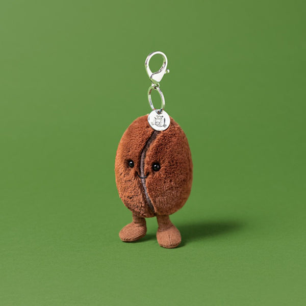 Plush keychain shaped like a coffee bean on a green background