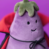 Plush toy resembling an eggplant with a smiling face on a purple background
