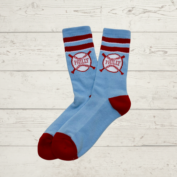 Blue socks with red accents and 'Philadelphia' text on a light wooden surface