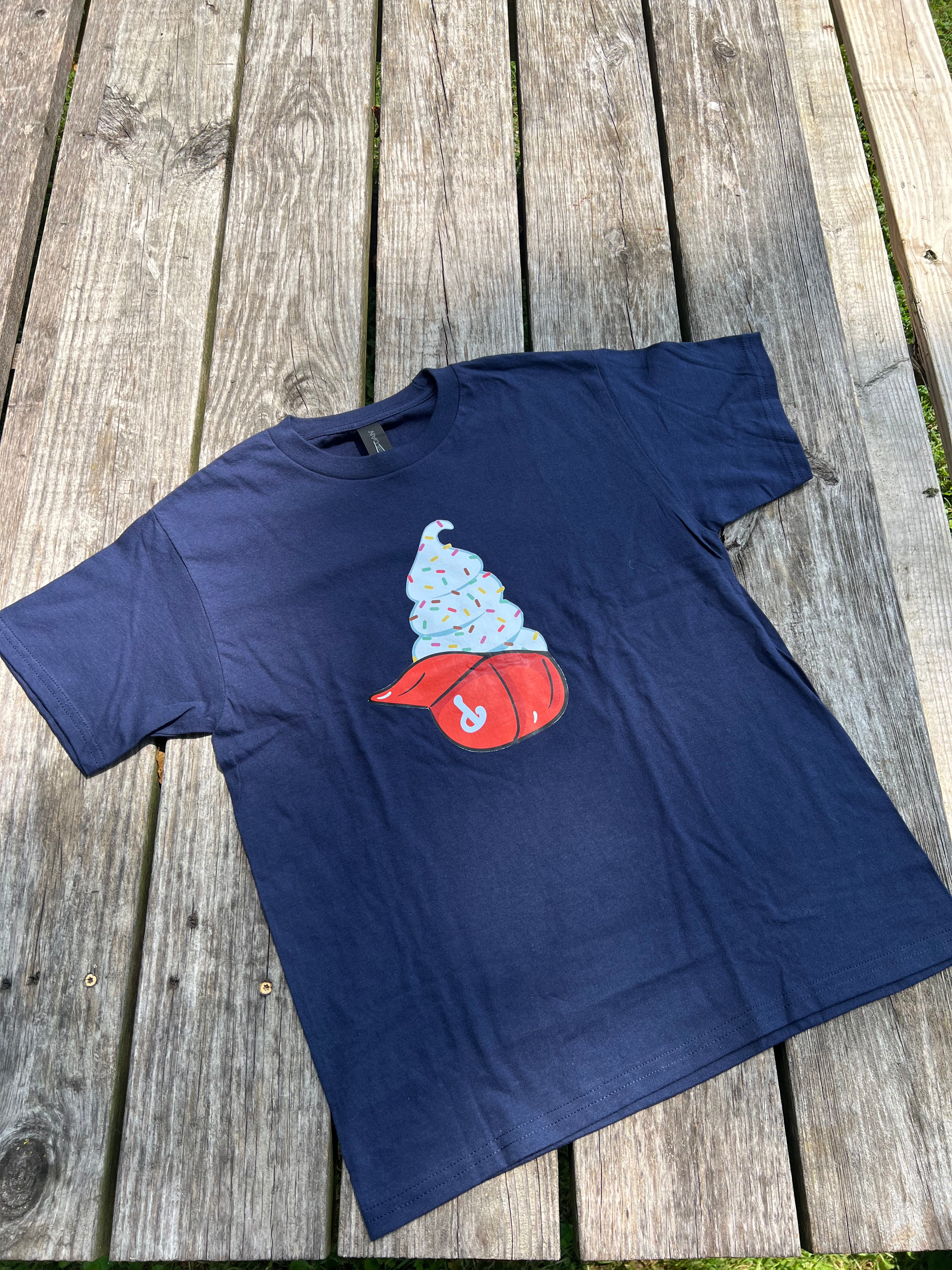 Navy blue t-shirt with a graphic design on a wooden surface