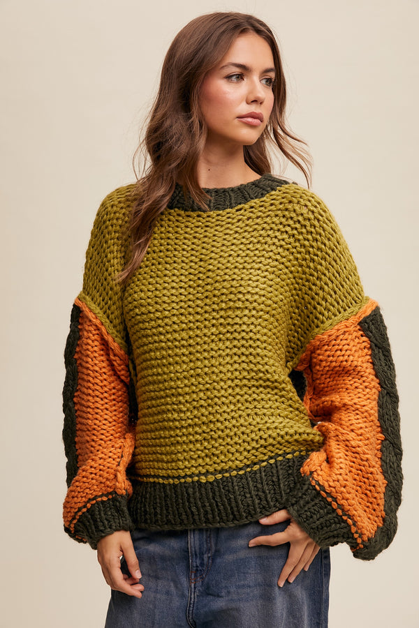 Woman wearing a green and orange chunky knit sweater on a beige background